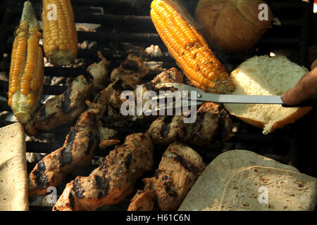 La cuisson de la viande, du pain, et le maïs à l'extérieur camping Banque D'Images