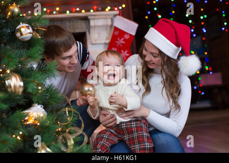 Mère, père et fils decorating Christmas Tree in living room Banque D'Images