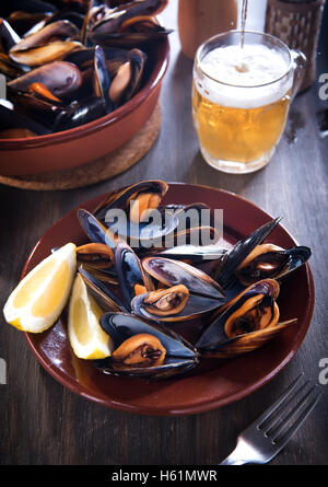 Les moules cuites à la bière fraîche sur un fond de bois Banque D'Images