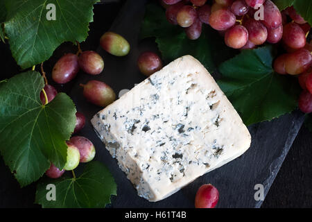 Dorblu avec fromage bleu raisin rouge sur fond noir Banque D'Images