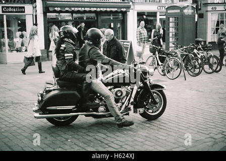 Moto Harley Davidson fait son chemin à travers les consommateurs sur le Watergate street à Chester England tourné avec Kodak BW400 film Banque D'Images