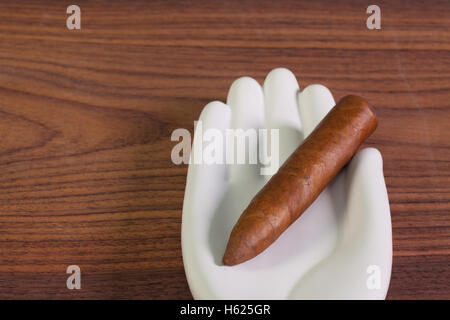 Cigare cubain de luxe en céramique de main et sur la table en bois. Banque D'Images