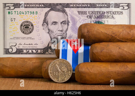 Cigares Cubains de luxe avec des billets et pièces en dollars US sur la table en bois. Banque D'Images