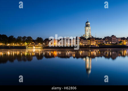 L'IJssel à Deventer le matin pendant l'heure bleue avec la grande église ou Lebuinuskerk dans la province d'Overijssel. Banque D'Images