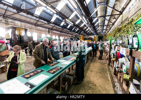 CAMRA beer festival dans le vieux hangar à locomotives Tunbridge Wells, Royaume-Uni. La sélection de personnes de diverses bières, fûts, barils de bière derrière un long comptoir. Banque D'Images