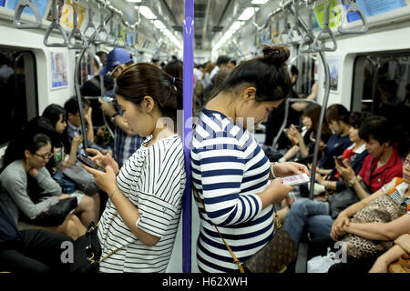 Séoul, Corée du Sud. 24 Oct, 2016. Deux femmes sont à la recherche à leur téléphone cellulaire dans le métro. © Min Won-Ki/ZUMA/Alamy Fil Live News Banque D'Images