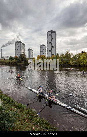 Les rameurs sur la rivière Clyde à l'ouest d'un hangar à bateaux et Gorbals en arrière-plan Banque D'Images