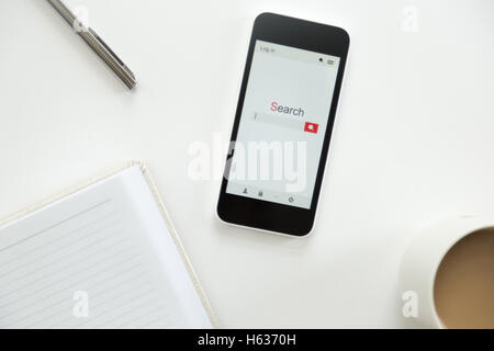 Vue de dessus d'un téléphone mobile situé sur un bureau blanc 24 Banque D'Images