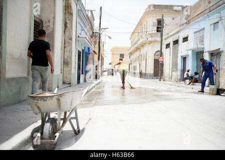 Nettoyage à l'eau femme de la rue avec un mop ; général Street view à Santiago de Cuba, Cuba. Banque D'Images