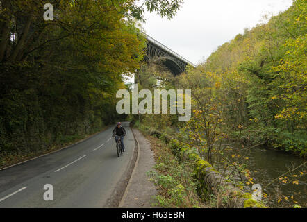 Un cycliste passe sous les ponts anciens à Millers Dale, Derbyshire, Royaume-Uni, une partie du sentier récréatif Monsal. Banque D'Images