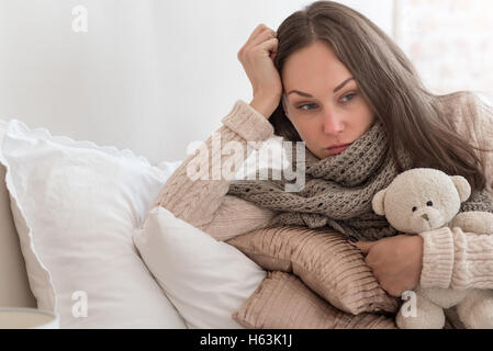 Triste thoughtful woman lying on pillows Banque D'Images