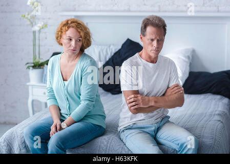 Furieux de couple assis sur le lit Banque D'Images