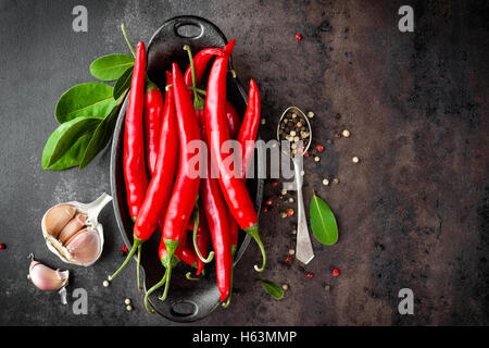 Red hot chili pepper corns et les gousses sur dark old metal background culinaire Banque D'Images