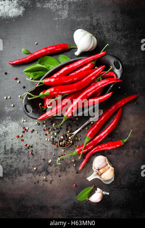 Red hot chili pepper corns et les gousses sur dark old metal background culinaire Banque D'Images