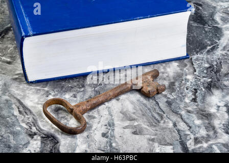 Clé squelette fer antique avec de gros livre bleu avec prix pour votre type. Banque D'Images