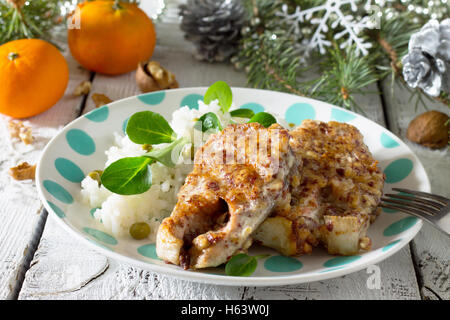 Du poisson cuit au four dans l'écrou de la panure sur la table de Noël. Banque D'Images