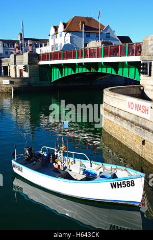 Vue de la feuille double pont à bascule dans le port avec un petit bateau à l'avant-plan, Weymouth, Dorset, Angleterre, Royaume-Uni. Banque D'Images