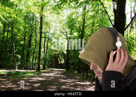 Man in hoodie listening to music on headphones Banque D'Images