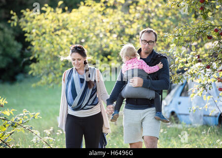 Les parents avec leurs enfants dans les transporteurs. Promenade dans la nature. Banque D'Images