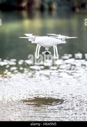 Drone quadcopter, avec un appareil volant au-dessus de l'eau. Banque D'Images