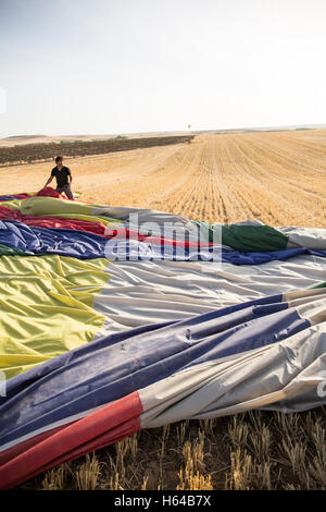 Homme d'emballer un ballon à air chaud dans le champ de l'enveloppe Banque D'Images