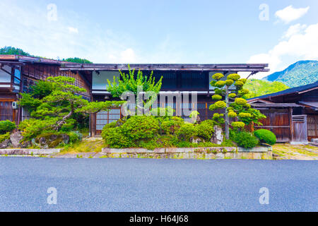 Avant d'une maison traditionnelle en bois avec jardin japonais manucurés avec soin sur la route Nakasendo à Tsumago, Japon Banque D'Images