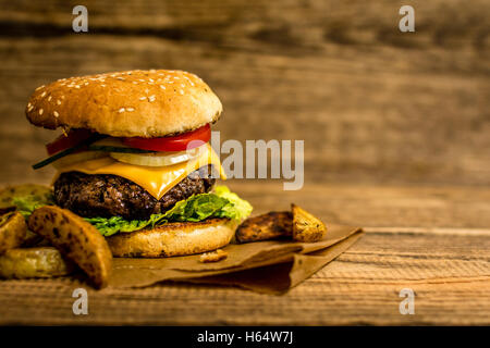 Hamburger de bœuf grillé avec des légumes sur la table en bois Banque D'Images