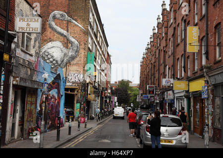 Les graffitis, les voitures et les gens sur la rue Hanbury, une ruelle latérale venant de Brick Lane à Shoreditch. Londres, Angleterre, Grande-Bretagne 18,08 Banque D'Images