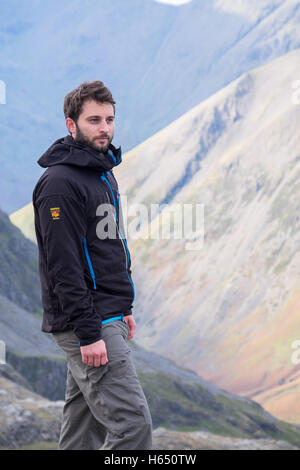 Homme dans la mi-vingtaine randonnées dans le Lake District, vêtu d'une veste Paramo Banque D'Images