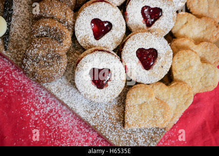 Cookies et biscuits présentés sur une planche en bois avec des ingrédients à côté Banque D'Images