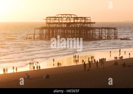 Brighton West Pier et les gens sur la plage au coucher du soleil, Brighton, East Sussex England UK Banque D'Images