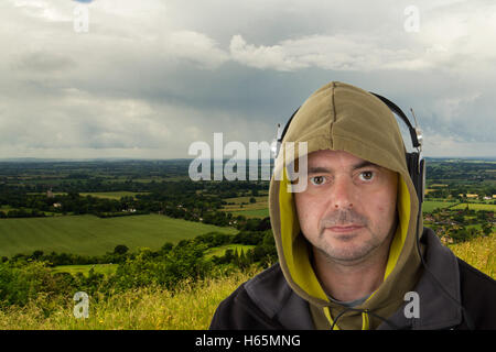 Man in hoodie listening to music on headphones Banque D'Images