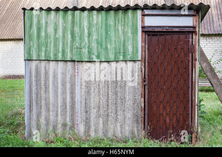 Close up d'un old weathered barn avec porte métallique. Banque D'Images