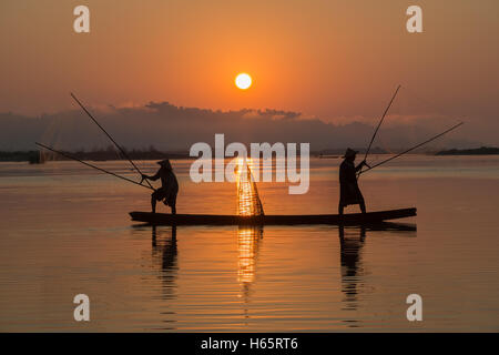 Couple de pêcheurs en Asie sur le bateau lors de la pêche d'action Banque D'Images
