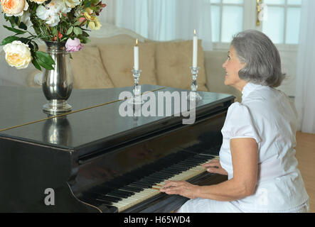 Femme jouant du piano à la maison Banque D'Images