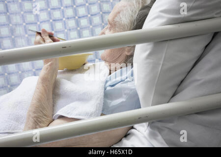 Quatre-vingt-dix ans de manger au lit du patient à l'hôpital Service de santé en Angleterre, Royaume-Uni. Banque D'Images