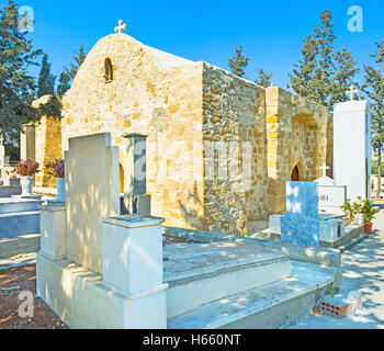 Le petit cimetière et l'église en pierre médiévale sur l'arrière-plan, Maroni, Chypre. Banque D'Images