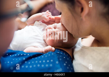 Les parents méconnaissables tenant leur fils nouveau-né, les baisers h Banque D'Images