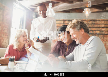 Waiter taking commander au restaurant table Banque D'Images