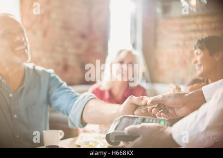 Serveur client de payer avec carte de crédit au restaurant table Banque D'Images