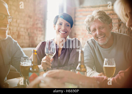 Rire des couples de boire le vin blanc et la bière au restaurant table Banque D'Images