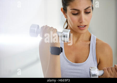 L'accent woman doing biceps avec haltères Banque D'Images