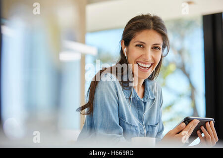 Enthousiaste Portrait woman using digital tablet et écouteurs Banque D'Images