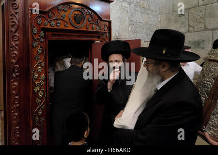 Les juifs religieux de la Torah scrolls retour à l'arche de la Torah penderie qui contient les rouleaux de la Torah juive alors qu'ils célèbrent la Simchat Torah une fête juive qui célèbre et marque la conclusion du cycle annuel des lectures de la Torah, et le début d'un nouveau cycle dans le mur ouest vieille ville Jérusalem Israël Banque D'Images