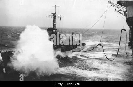 Royal Naval destroyer HMS Lagos se place le long du porte-avions HMS Unicorn en mer de Chine du Sud pour faire le plein par gros temps Banque D'Images