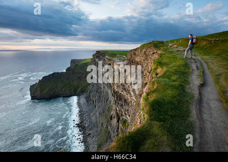 Randonneur au sommet des falaises de Moher, comté de Clare, Irlande. Banque D'Images