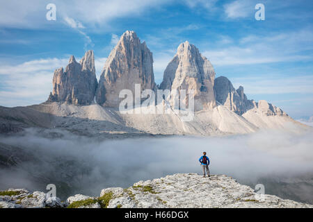 Randonneur et nuée du matin sous Tre Cime di Lavaredo. Dolomites de Sexten, Tyrol du Sud, Italie. Banque D'Images