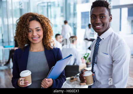 Smiling business colleagues having coffee in office Banque D'Images
