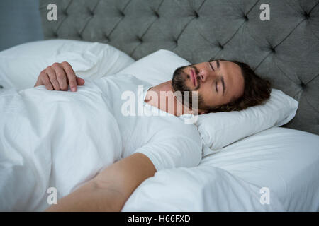 L'homme de dormir sur son lit Banque D'Images