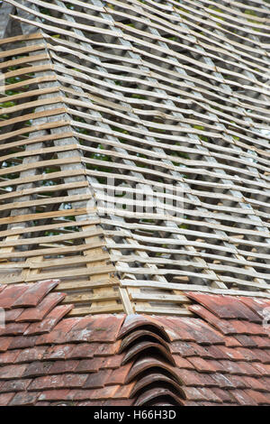 La construction de toit sur une maison médiévale avec peg Kentish Weald et tuiles à Downland Open Air Museum, Singleton, Sussex, Angleterre Banque D'Images